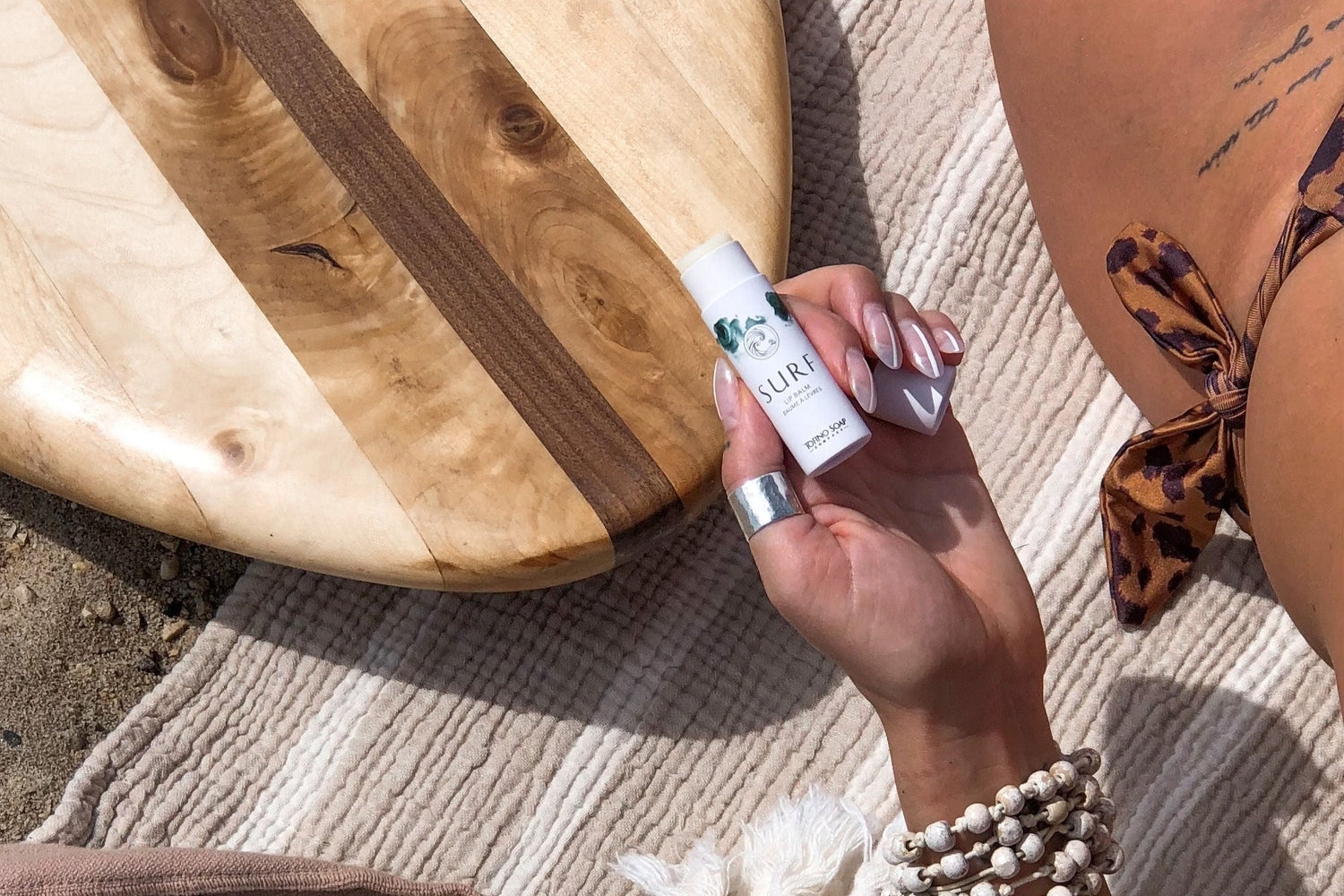 surf lip balm on beach blanket