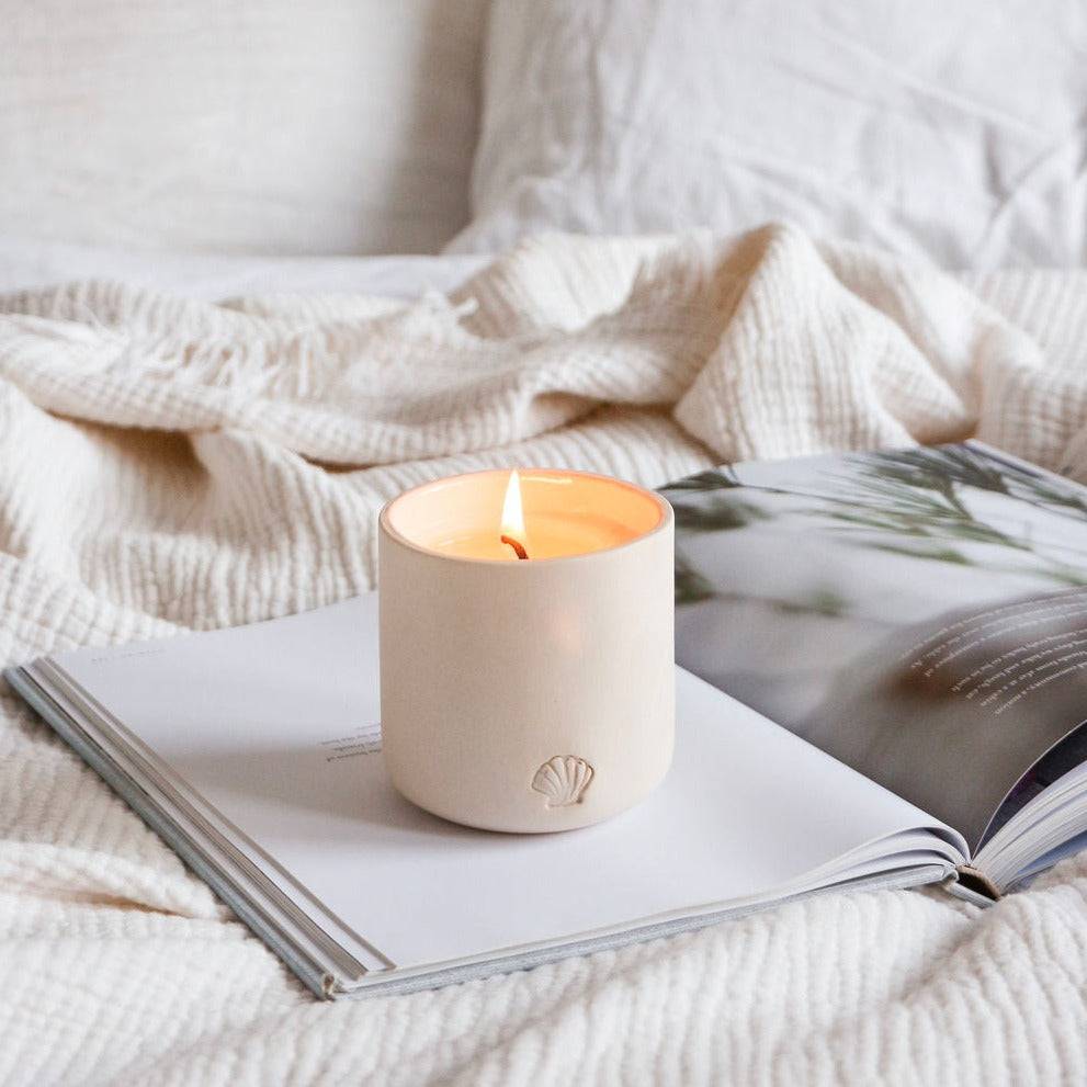 cozy tofino coastal candle on linens