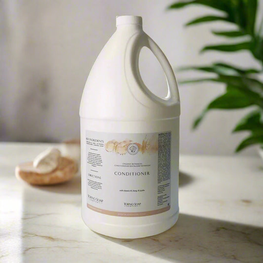 Large white bottle of conditioner on a light surface with a neutral background
