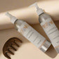 Two bottles of shampoo and conditioner with a wooden comb on a beige background