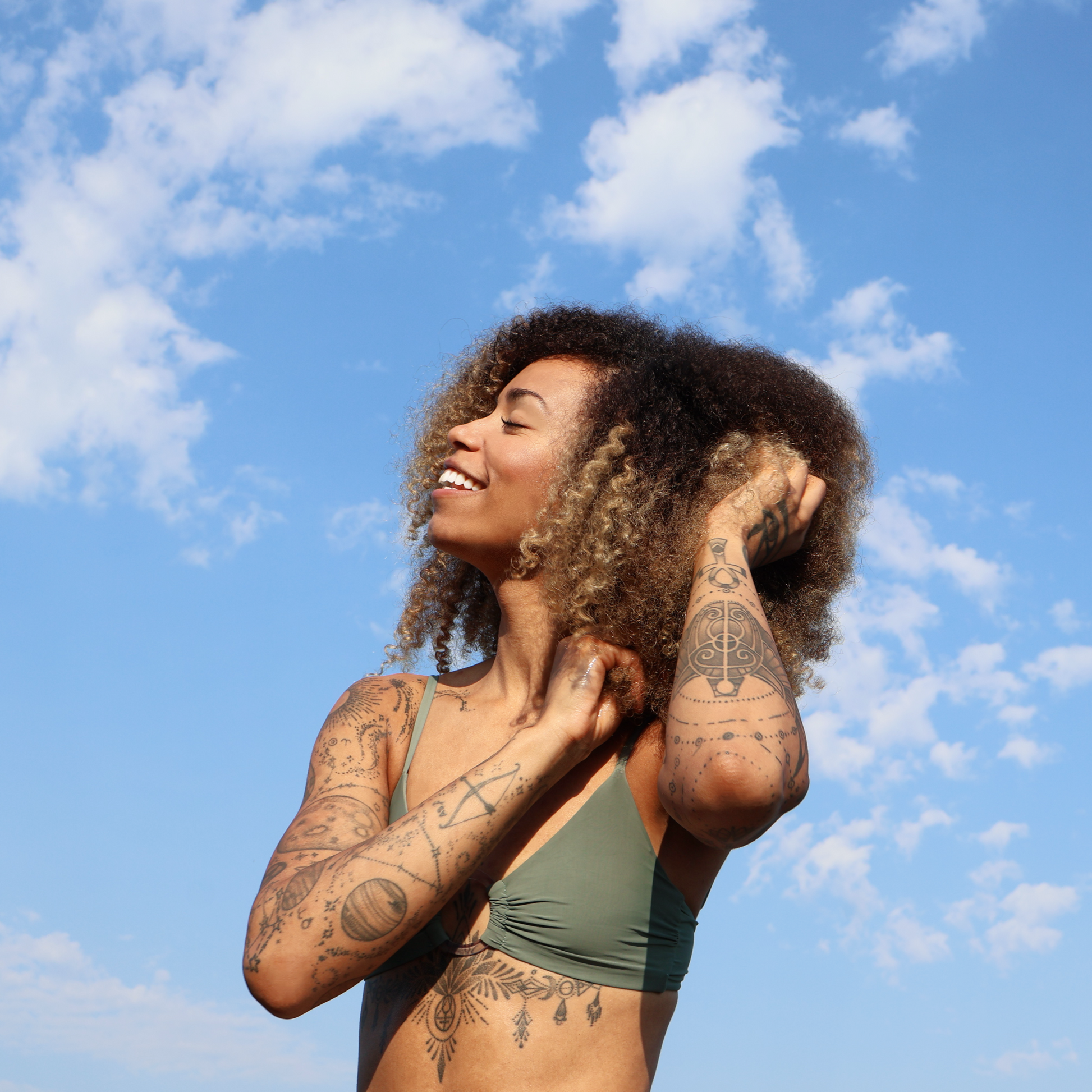 Woman with tattoos against a blue sky